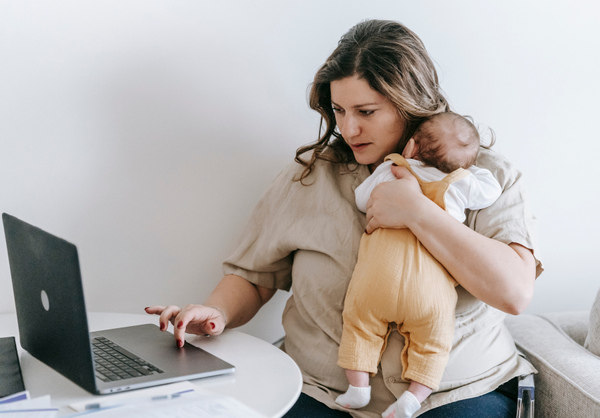 A woman working while holding her baby